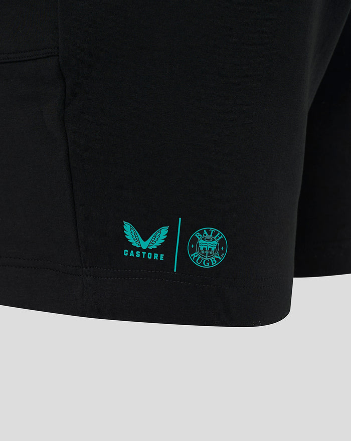 Close up of a black shorts leg with teal Castore and Bath Rugby logos near the lower hem.