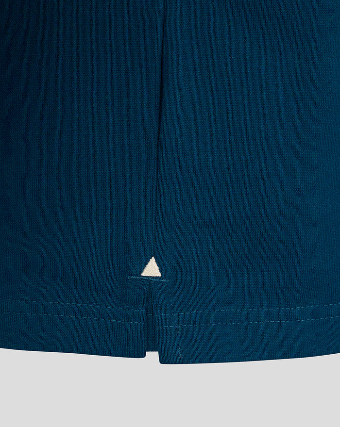 Teal rugby shirt hem close up with a small white triangle accent at the center bottom